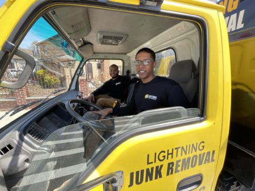 lightning junk removal crew smiling in junk removal truck