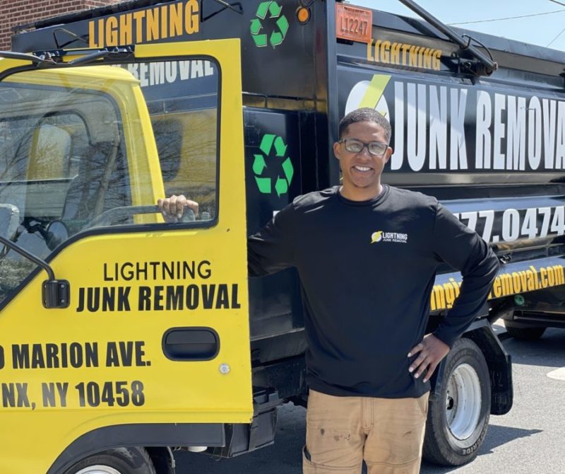 lightning junk removal pro posing in front of junk removal truck