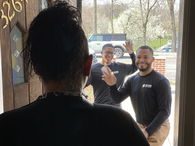 Junk removal professionals greeting a customer at the door before mattress removal services