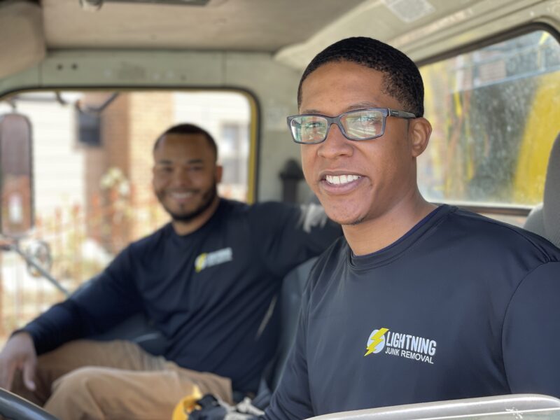 Junk removal professionals smiling in the truck